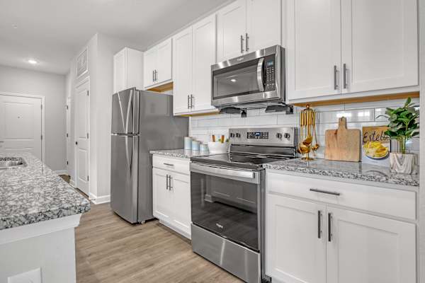 A kitchen with white cabinets and stainless steel appliances.